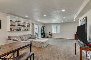 Carpeted living room featuring recessed lighting and baseboards