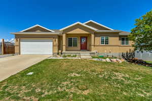 Ranch-style house with fence, an attached garage, a front lawn, stucco siding, and concrete driveway