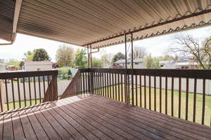 Wooden terrace featuring a yard, a residential view, and a fenced backyard