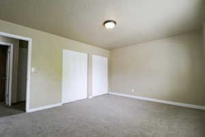 Unfurnished bedroom featuring baseboards and carpet flooring
