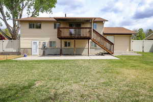 Rear view of property with a lawn, a gate, a patio area, stairway, and a fenced backyard