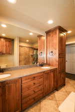 Bathroom with recessed lighting, a textured ceiling, a sink, and tile patterned flooring