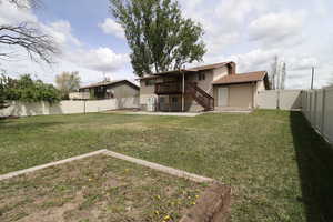 View of yard featuring a wooden deck, a fenced backyard, stairs, a gate, and a patio area