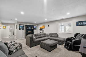 Living area with light carpet, recessed lighting, a textured ceiling, and visible vents