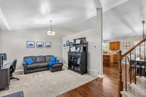 Living area featuring visible vents, baseboards, dark wood-type flooring, and stairway