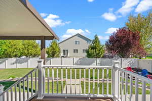 Wooden deck with a fenced backyard and a lawn