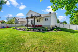 Back of property with a lawn, a patio, a gate, and a fenced backyard