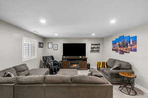 Carpeted living area with recessed lighting and baseboards