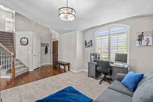Office featuring baseboards, carpet, vaulted ceiling, and wood finished floors