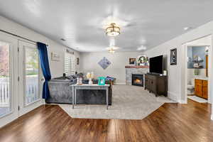 Living area featuring baseboards, visible vents, wood finished floors, and a fireplace