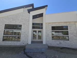 View of exterior entry featuring french doors and stone siding