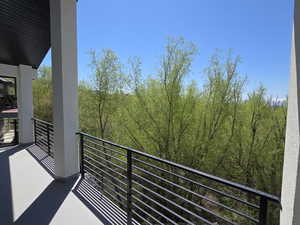 Balcony featuring a wooded view