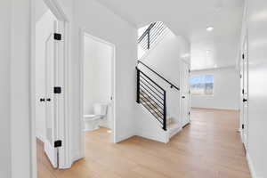 Stairway featuring recessed lighting, baseboards, and wood finished floors