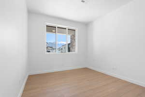 Spare room with baseboards, light wood finished floors, and visible vents