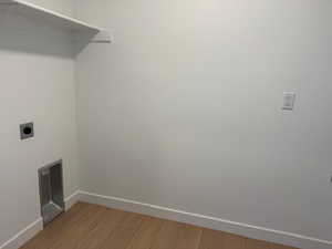 Washroom featuring hookup for an electric dryer, laundry area, baseboards, and light wood-style floors