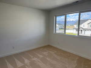 Spare room featuring visible vents, baseboards, and light carpet