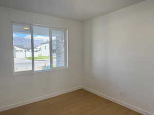 Unfurnished room with baseboards and light wood-type flooring