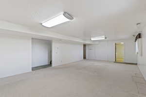 Spare room with a textured ceiling and light colored carpet