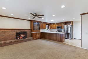 Kitchen featuring recessed lighting, glass insert cabinets, stainless steel appliances, and a peninsula