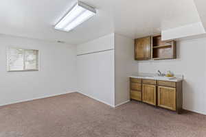Bar with baseboards, a sink, visible vents, and light carpet