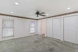 Unfurnished bedroom featuring a ceiling fan, baseboards, multiple closets, carpet flooring, and recessed lighting