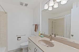 Full bath with tile patterned floors, vanity, toilet, and visible vents