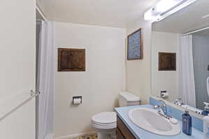 Bathroom featuring vanity, toilet, a textured ceiling, and a shower with shower curtain