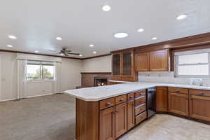 Kitchen featuring a sink, dishwasher, and brown cabinets