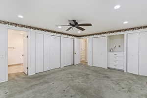 Unfurnished bedroom featuring carpet flooring, recessed lighting, multiple closets, and ensuite bath