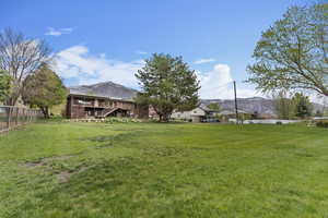 View of yard featuring stairs, a mountain view, and fence