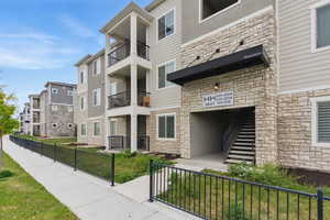 View of building exterior featuring fence, stairway, and a residential view