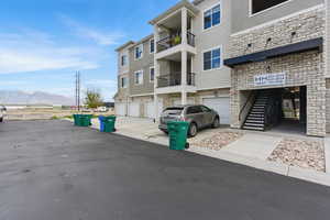 View of building exterior with driveway, a mountain view, and an attached garage