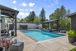 View of heated swimming pool with automatic cover and hot tub