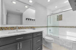 Full bathroom with skylight, granite countertops and tile