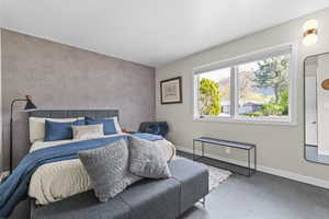 Bedroom featuring Omexco wallpaper, multiple windows, tile floors