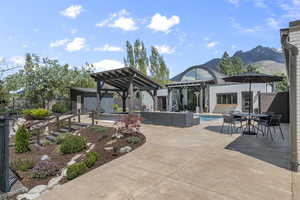 View of patio with fence, a fenced in pool, a gazebo, an outbuilding, and outdoor dining space