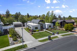 View of front of property with concrete driveway, fence, a front yard, and a garage
