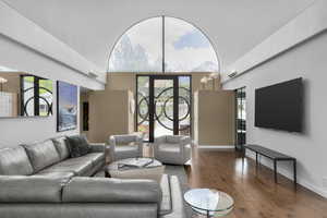 Living room featuring Hardwood Maple floors, an arched towering ceiling, Custom Entry Door by Iron Door Works