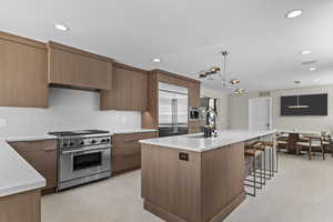 High end kitchen with Custom rift sawn white oak cabinetry with custom stain color, Silestone countertops that go up the wall, back splash, gas Wolf range with griddle, Sub zero fridge with water filter, Cabinet front dishwasher/bosch dishwasherBosch draw