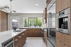 High end kitchen with Custom rift sawn white oak cabinetry with custom stain color, Silestone countertops that go up the wall, back splash, gas Wolf range with griddle, Sub zero fridge with water filter, Cabinet front Bosch dishwasher, Bosch drawer microw