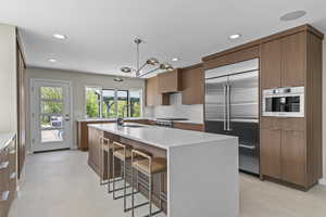 High end kitchen with Custom rift sawn white oak cabinetry with custom stain color, Silestone countertops that go up the wall, back splash, gas Wolf range with griddle, Sub zero fridge with water filter, Cabinet front dishwasher/bosch dishwasherBosch draw