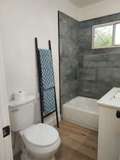 Full bath featuring toilet, a sink, and wood finished floors