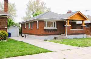 View of front of property with brick siding, a chimney, and a front lawn