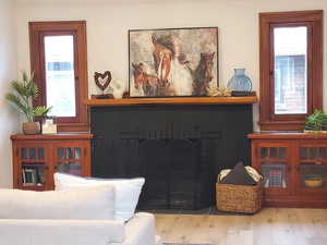 Living room featuring a firplace with built in book cases.