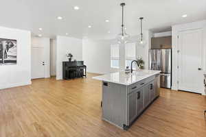 Kitchen with appliances with stainless steel finishes, a sink, gray cabinetry, light countertops, and recessed lighting