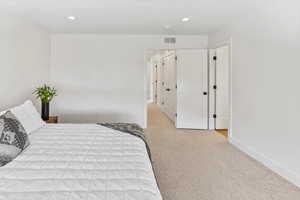 Bedroom featuring visible vents, recessed lighting, baseboards, and light colored carpet