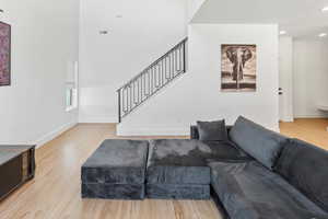 Living room featuring stairs, baseboards, and wood finished floors