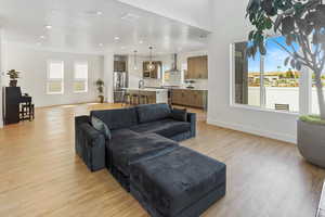Living area with baseboards, recessed lighting, and light wood finished floors