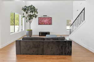 Living area featuring baseboards, stairway, and light wood-type flooring