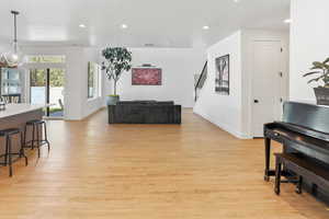 Living room with light wood-type flooring, recessed lighting, and baseboards